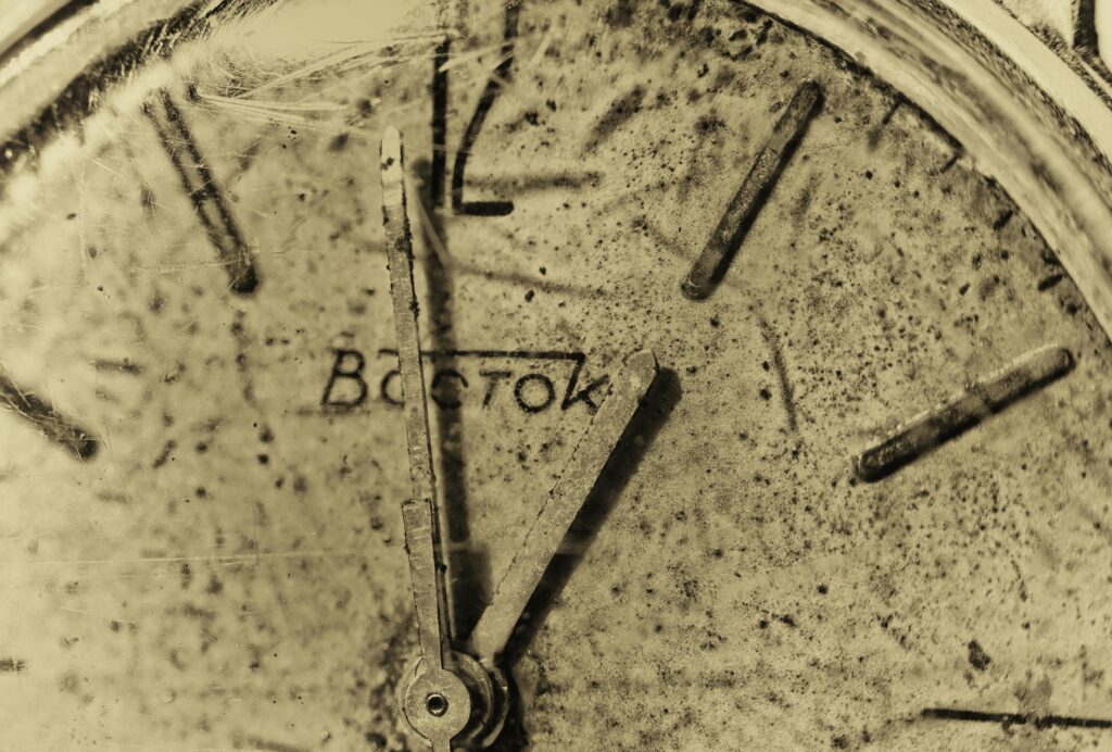 A striking close-up shot of a broken vintage clock with scattered gears and frozen hands. The fractured timepiece captures the stillness of a moment caught out of time, reflecting the themes of rigid traditions and what happens when structures stay frozen from the blog "When Rules Outlive Their Purpose" by Dhrruv Tokas.